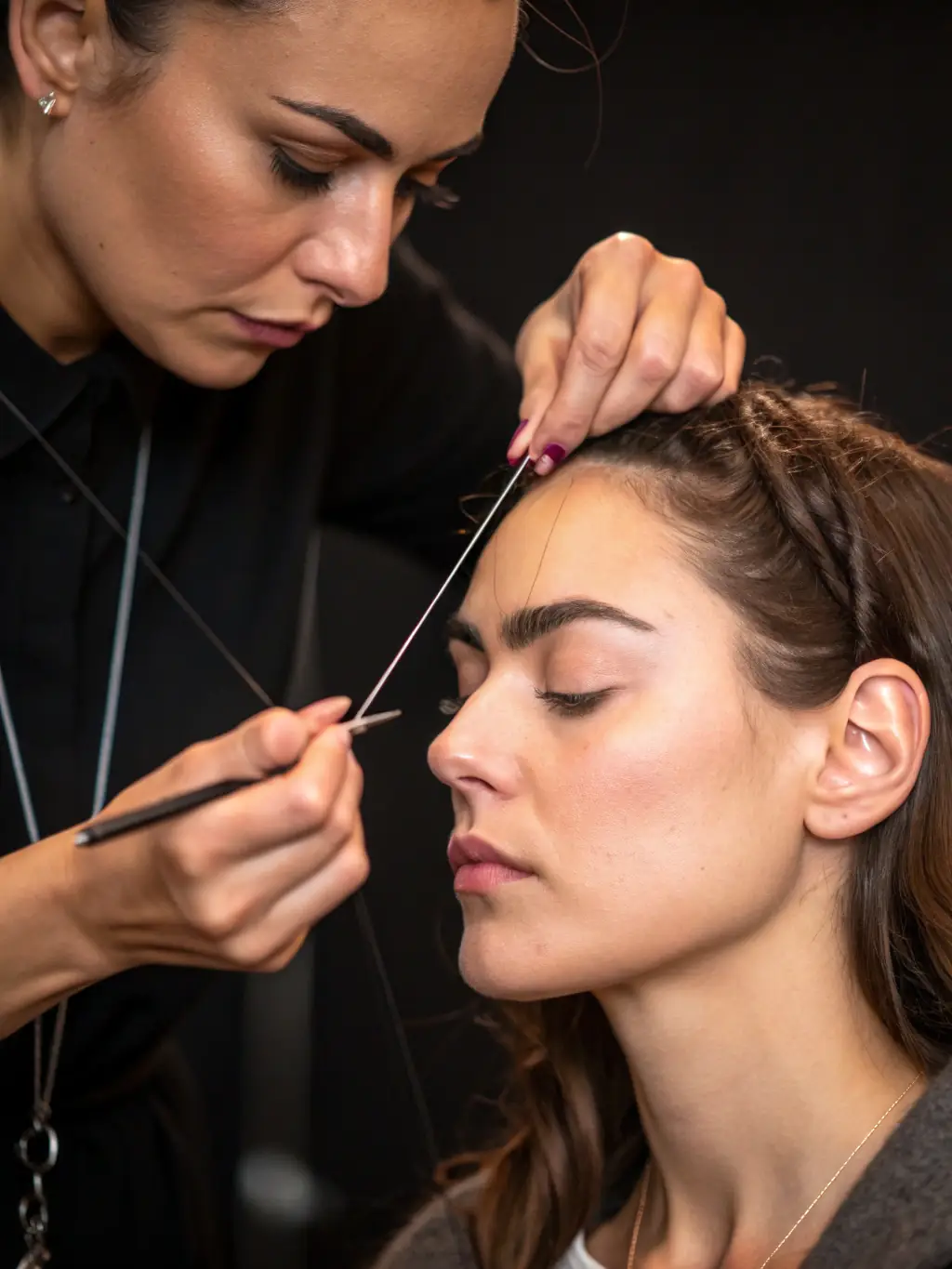 A beautician carefully threading a client's eyebrows at Dubai Beauty Salon, emphasizing the precision and skill involved in the threading process.