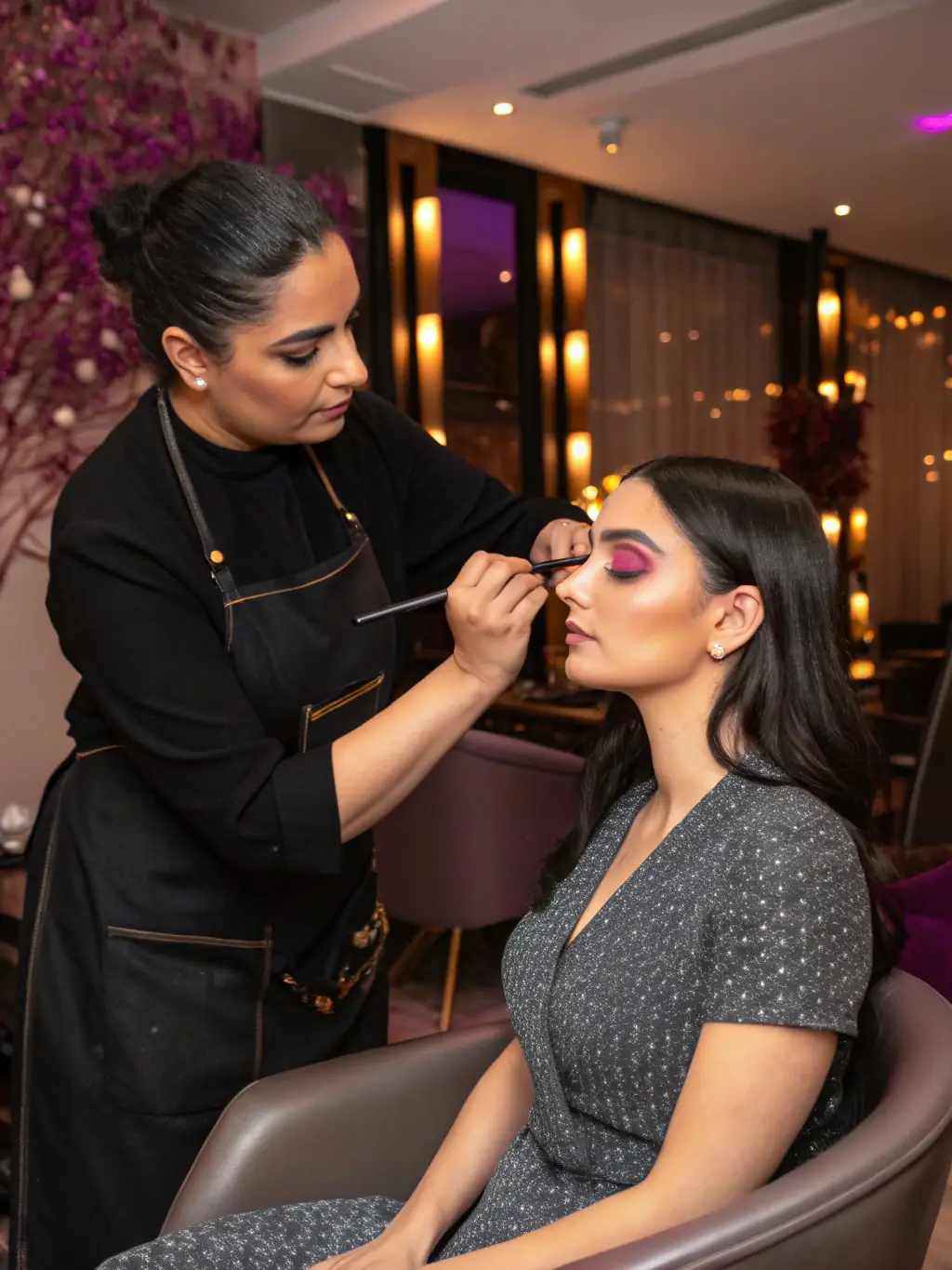 A student carefully applying makeup to a model's face during a makeup artistry class at Dubai Beauty Salon, demonstrating the hands-on training provided.